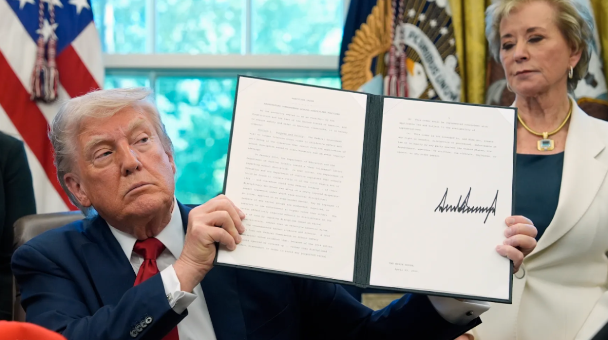 President Trump displays his signed executive order regarding his new school defunding policies in the White House.